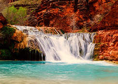 青く澄んだ水に横に広がる滝